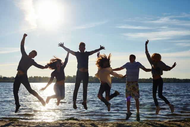 アメリカ留学の海辺でジャンプする留学生たち